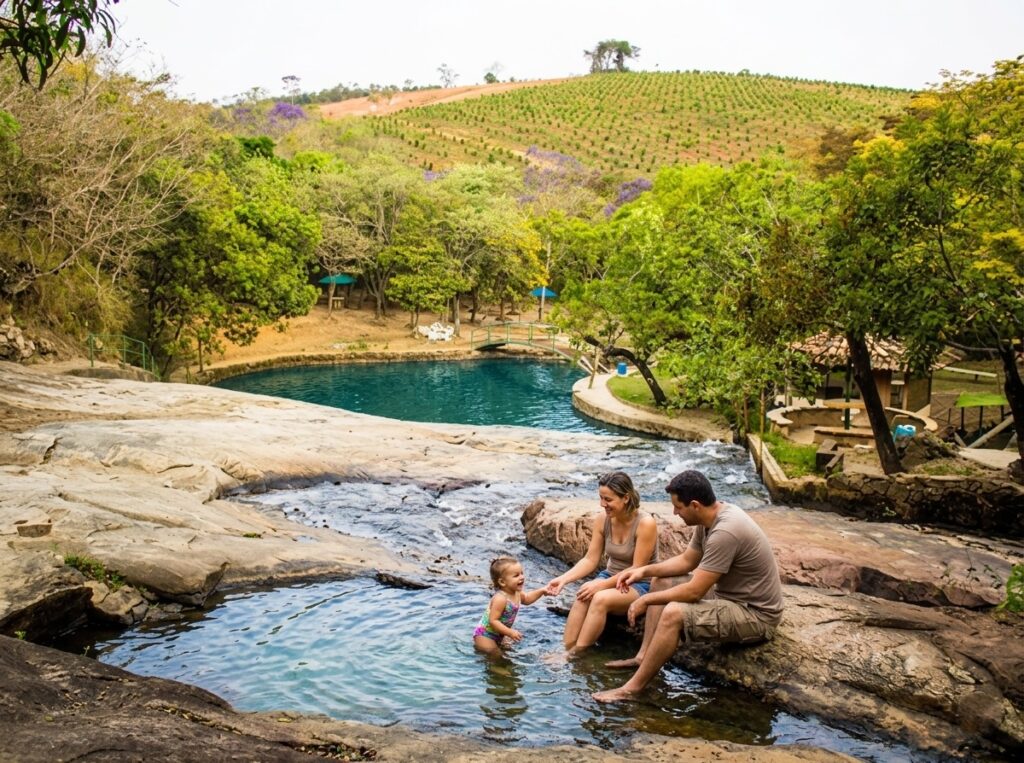 Família com criança pequena aproveitando piscina natural na Cachoeira do Moinho em Moeda, Minas Gerais, próximo ao Recanto do Bem Casa de Campo.